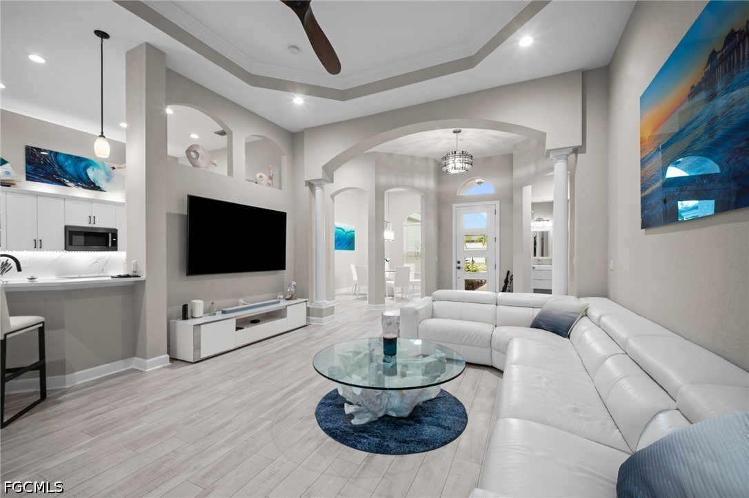 9042 Bronco Court Naples, FL 34113 - Photo 6 of 50 a living room with furniture a flat screen tv and a large window