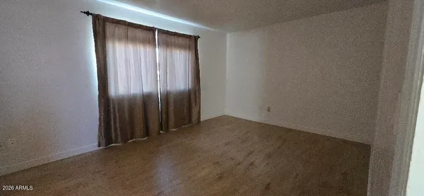 an empty room with wooden floor and closet area