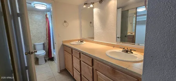 a bathroom with a granite countertop sink a toilet a mirror and shower