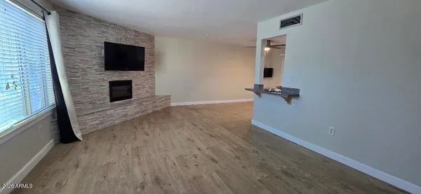 a view of a livingroom with wooden floor and a fireplace