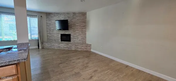 a view of a livingroom with wooden floor and a fireplace