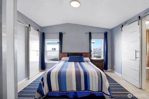 a bedroom with a bed and wooden floor