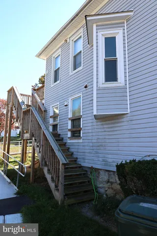 a view of a house with wooden deck and a yard