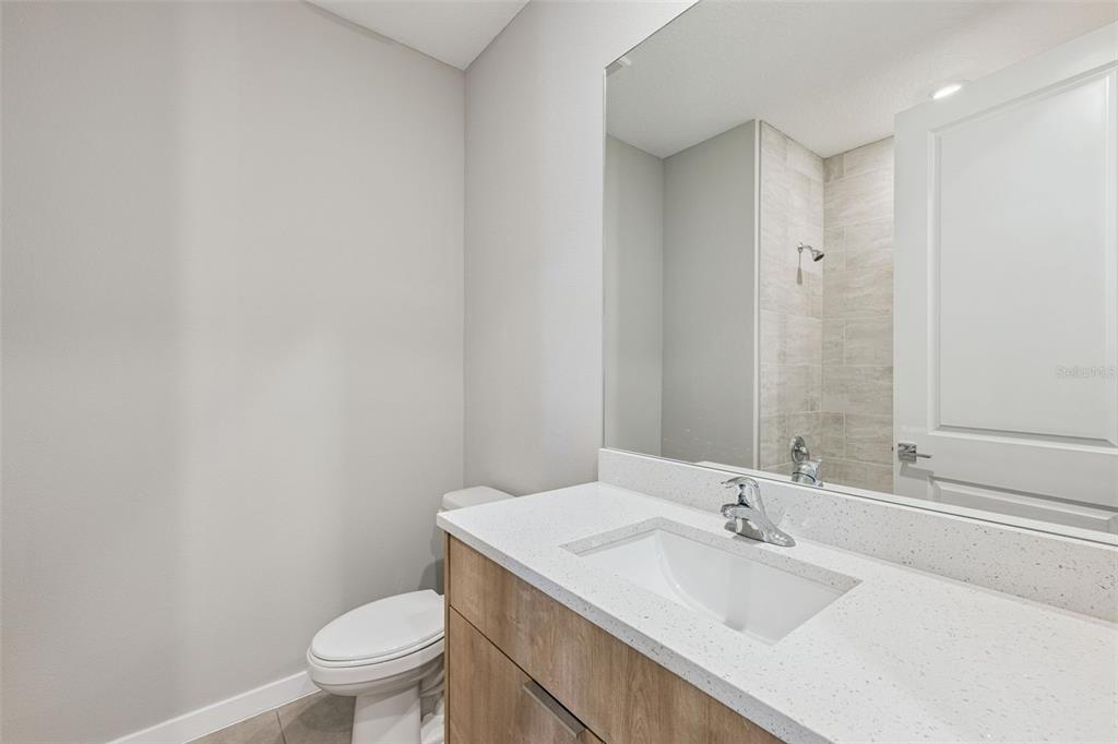 544 North Bumby Avenue, Unit 5 Orlando, FL 32803 - Photo 15 of 26 a bathroom with a granite countertop sink a toilet and a mirror