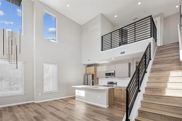 a view of staircase and kitchen with wooden floor