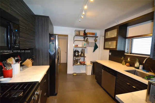 a kitchen with granite countertop stainless steel appliances and wooden cabinets