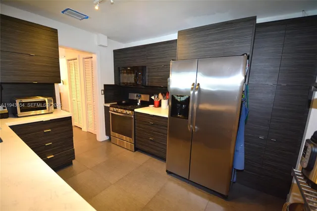 a kitchen with stainless steel appliances granite countertop a refrigerator and a sink
