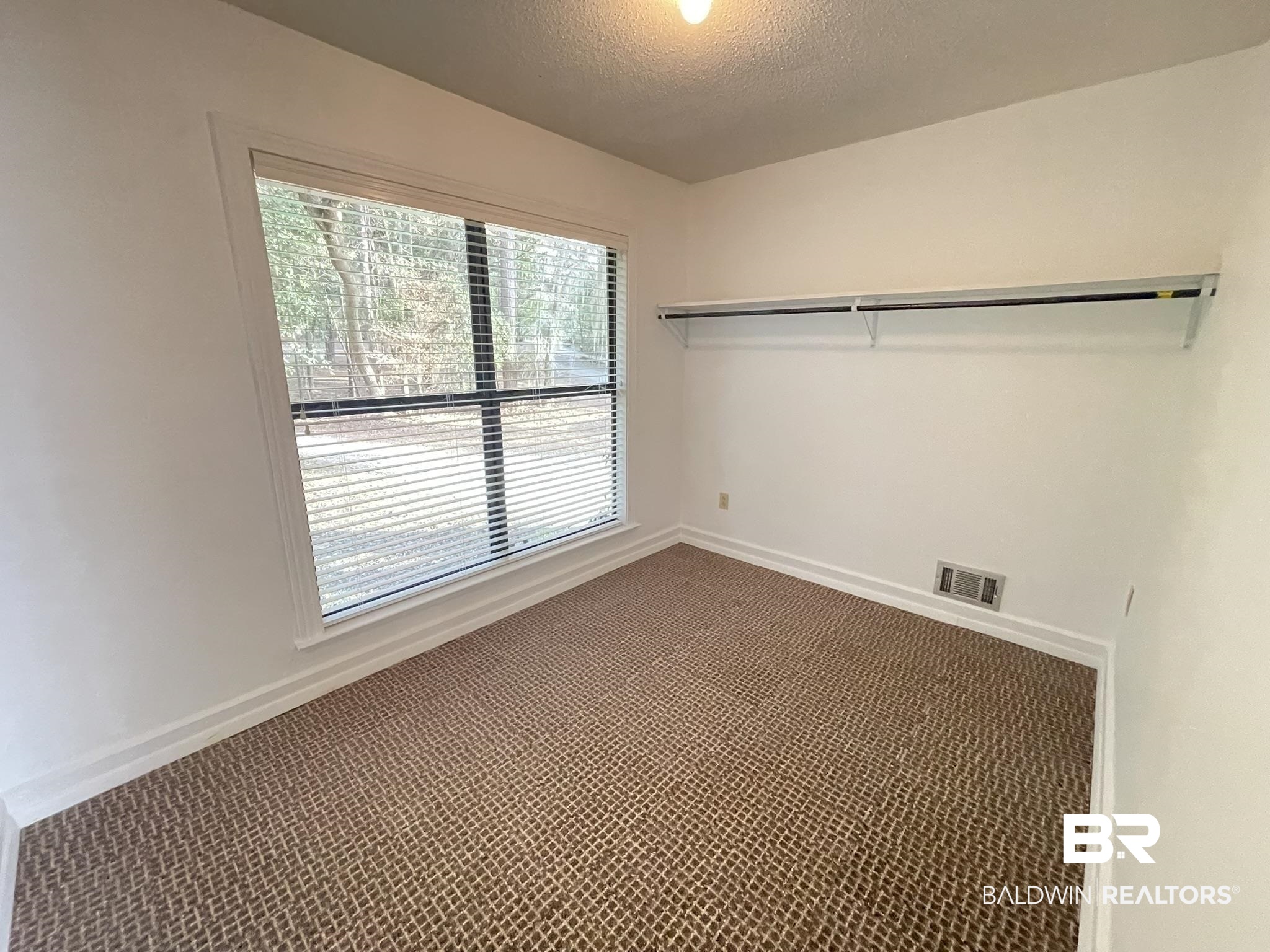 6621 Purvis Road Daphne, AL 36527 - Photo 39 of 59 Spare room featuring dark colored carpet and a textured ceiling