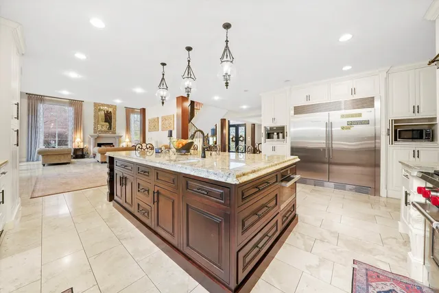 a kitchen with stainless steel appliances granite countertop a sink and white cabinets