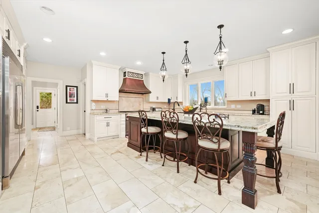 a large kitchen with stainless steel appliances kitchen island granite countertop a sink and cabinets