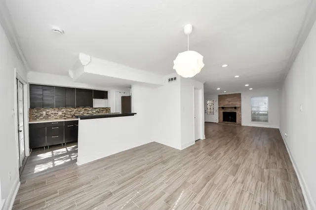 a view of empty room with wooden floor and fireplace