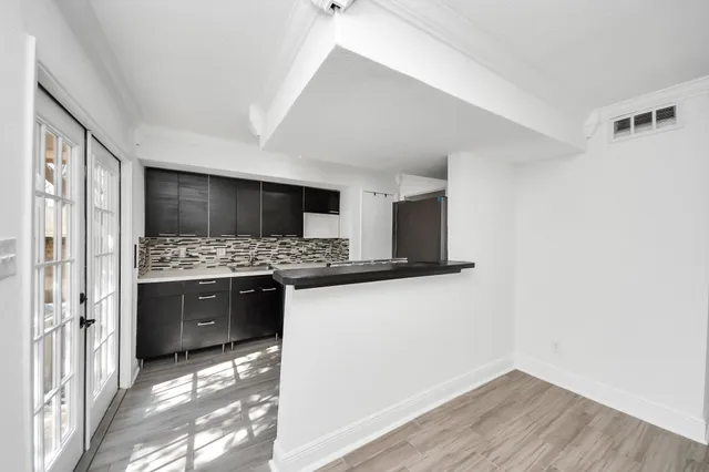 an empty room with wooden floor fireplace and windows