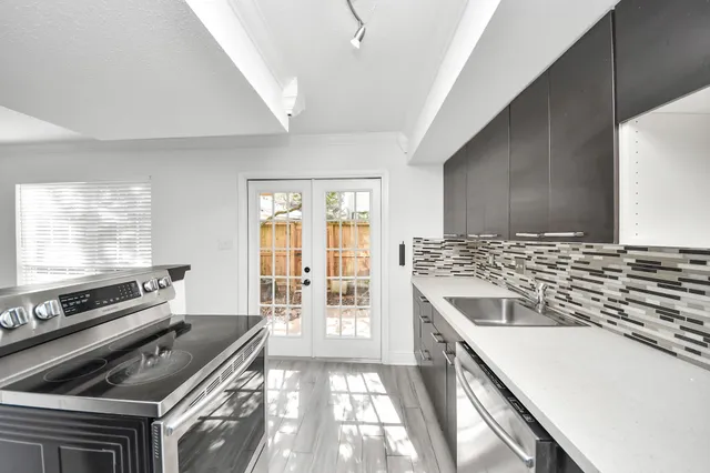 a view of an empty room with wooden floor fireplace and a window