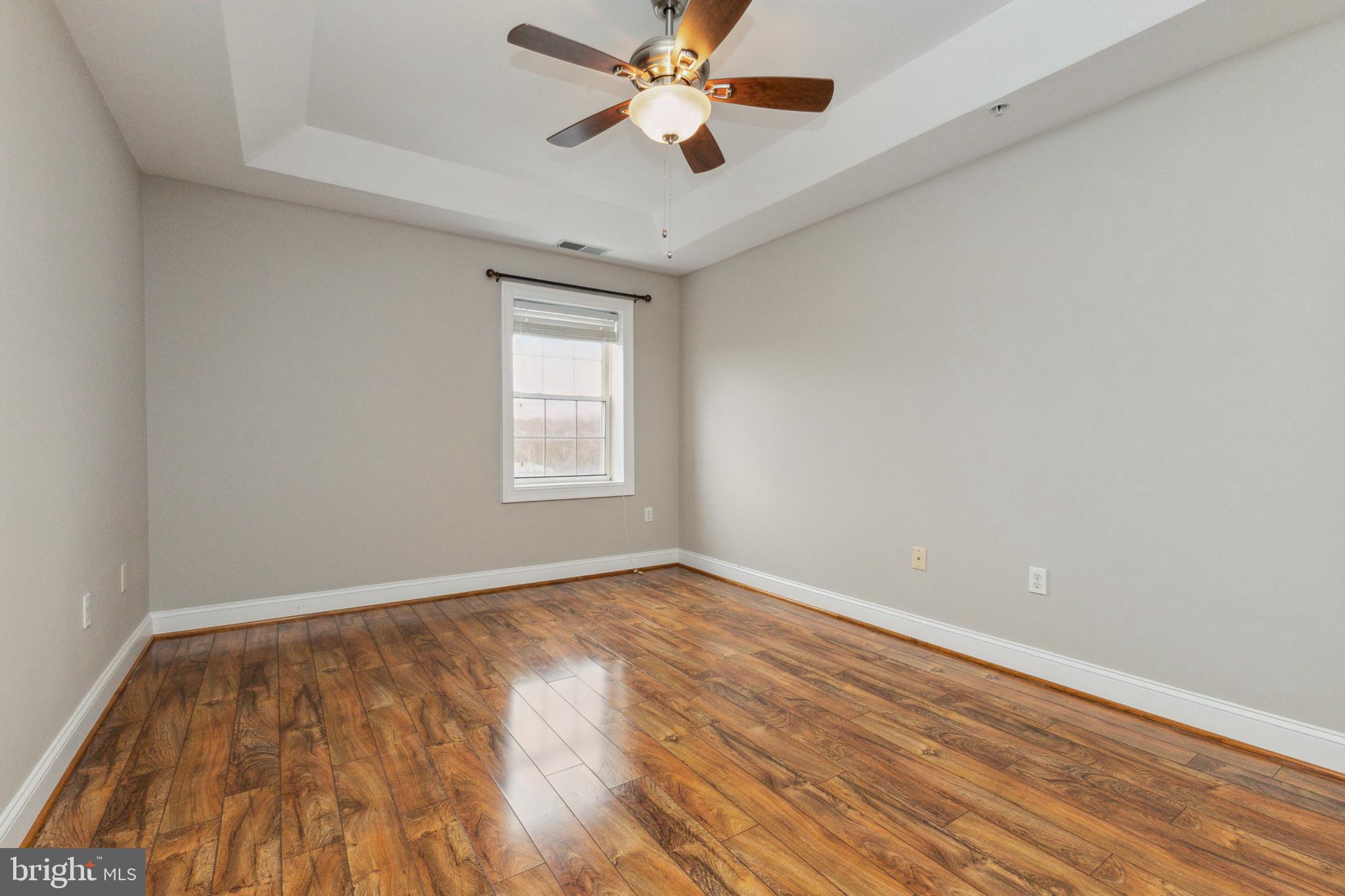 6301 Edsall Road, Unit 513 Alexandria, VA 22312 - Photo 26 of 38 an empty room with wooden floor ceiling fan and windows