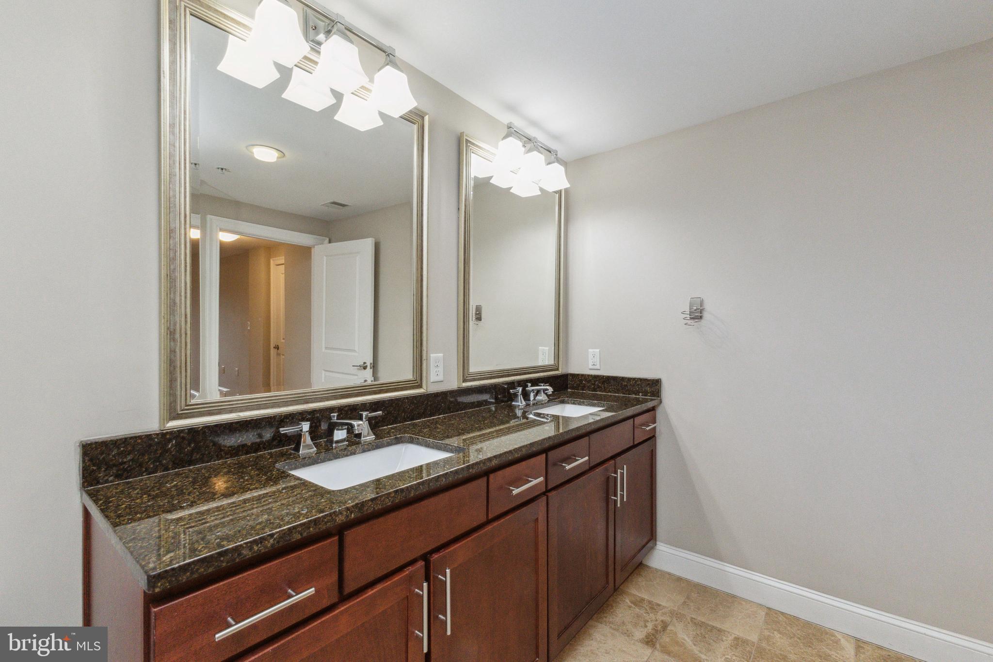 6301 Edsall Road, Unit 513 Alexandria, VA 22312 - Photo 31 of 38 a bathroom with a granite countertop sink and a mirror