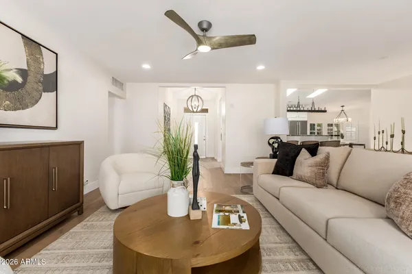 a kitchen with stainless steel appliances granite countertop a stove a sink dishwasher a dining table and chairs with wooden floor