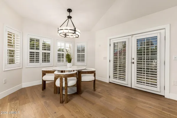 a kitchen with stainless steel appliances granite countertop a stove a sink dishwasher a dining table and chairs with wooden floor