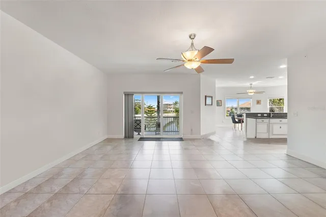 a dining room with chandelier fan and wooden floor