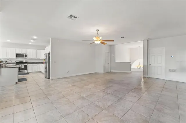 a living room with furniture a chandelier and a flat screen tv