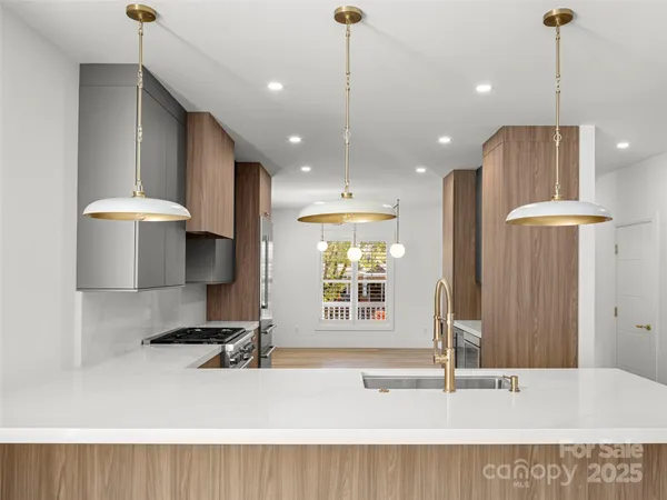 a kitchen with kitchen island a stove a sink and a refrigerator