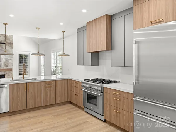 a kitchen with stainless steel appliances granite countertop a stove a sink and a refrigerator