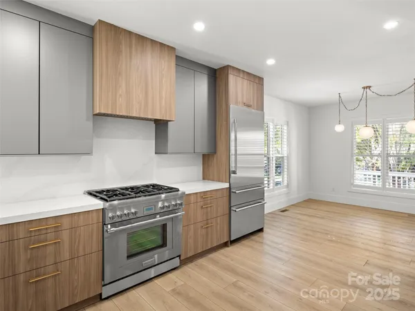 a kitchen with stainless steel appliances granite countertop a stove a sink and a refrigerator
