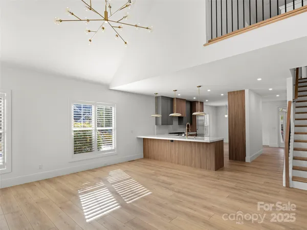 a large kitchen with kitchen island a stove a sink dishwasher and a refrigerator with wooden floor