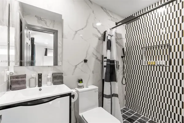 a bathroom with a sink toilet and shower