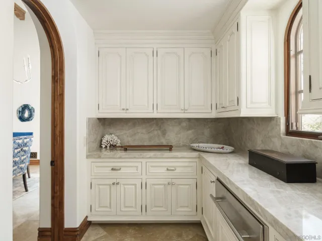 a kitchen with white cabinets and sink