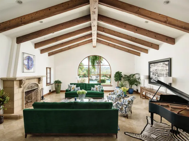 a living room with fireplace furniture and a view of kitchen