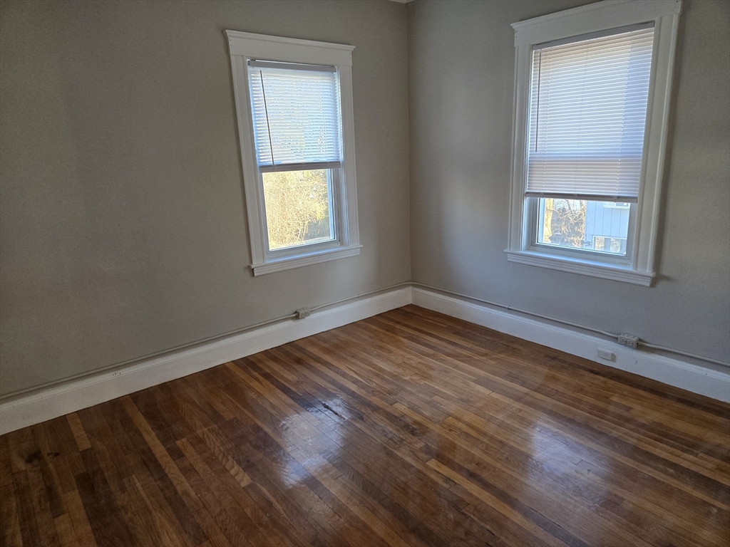 654 Metropolitan Avenue, Unit 4 Boston, MA 02136 - Photo 16 of 16 a view of an empty room with wooden floor and a window
