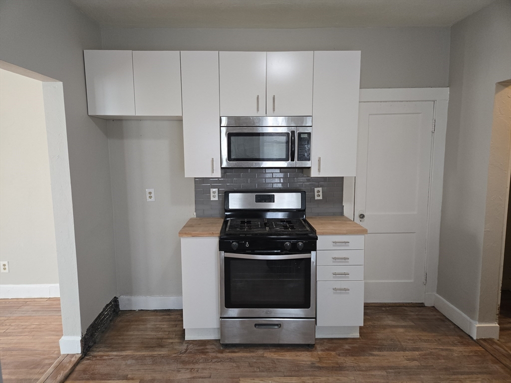 654 Metropolitan Avenue, Unit 4 Boston, MA 02136 - Photo 2 of 16 a kitchen with a stove and a microwave