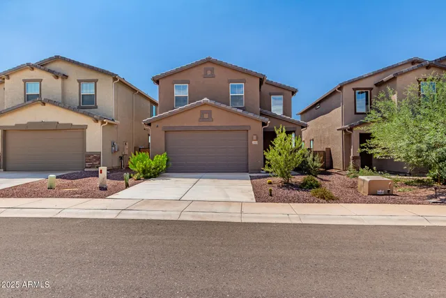 a front view of a house with a yard and a garage