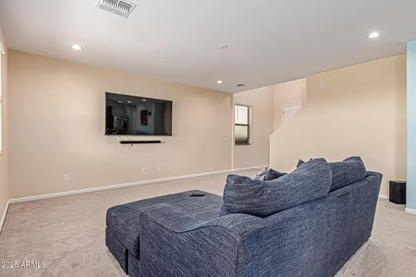 a living room with furniture a flat screen tv and a window