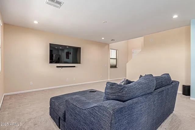 a living room with furniture a flat screen tv and a window
