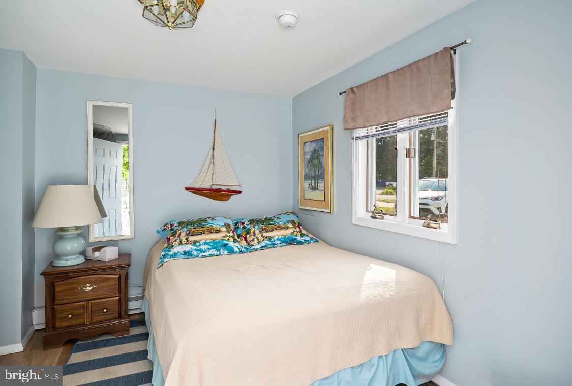 32789 Cedar Drive Ocean View, DE 19970 - Photo 11 of 18 a bedroom with a bed window and a chandelier