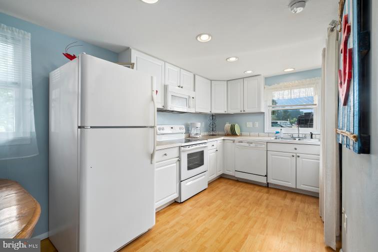 32789 Cedar Drive Ocean View, DE 19970 - Photo 7 of 18 a kitchen with white cabinets and white stainless steel appliances