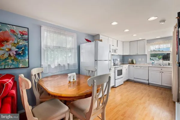a kitchen with stainless steel appliances refrigerator dining table and chairs