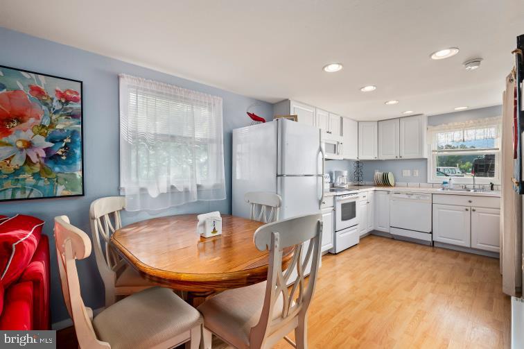 32789 Cedar Drive Ocean View, DE 19970 - Photo 8 of 18 a kitchen with stainless steel appliances refrigerator dining table and chairs