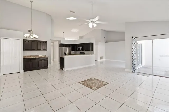 a kitchen with granite countertop a refrigerator and a stove top oven