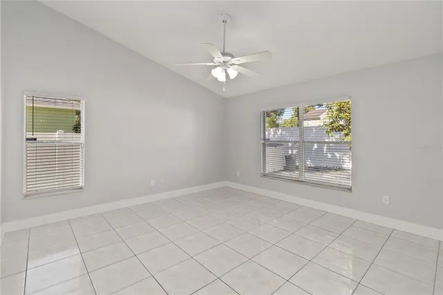 a view of an empty room and chandelier fan