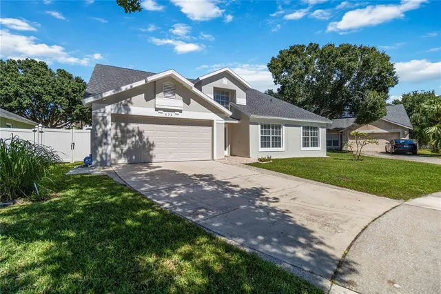 a view of a house with a big yard and large tree