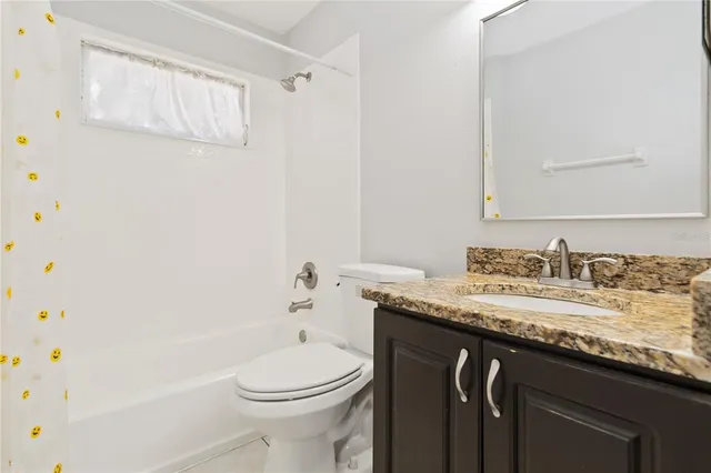 an empty room with windows and ceiling fan