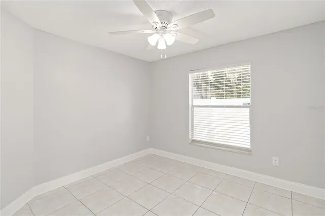 a view of an empty room and chandelier fan