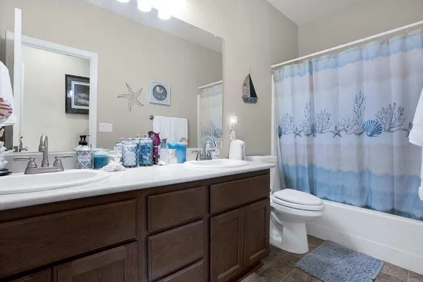 a bathroom with a double vanity sink toilet and shower