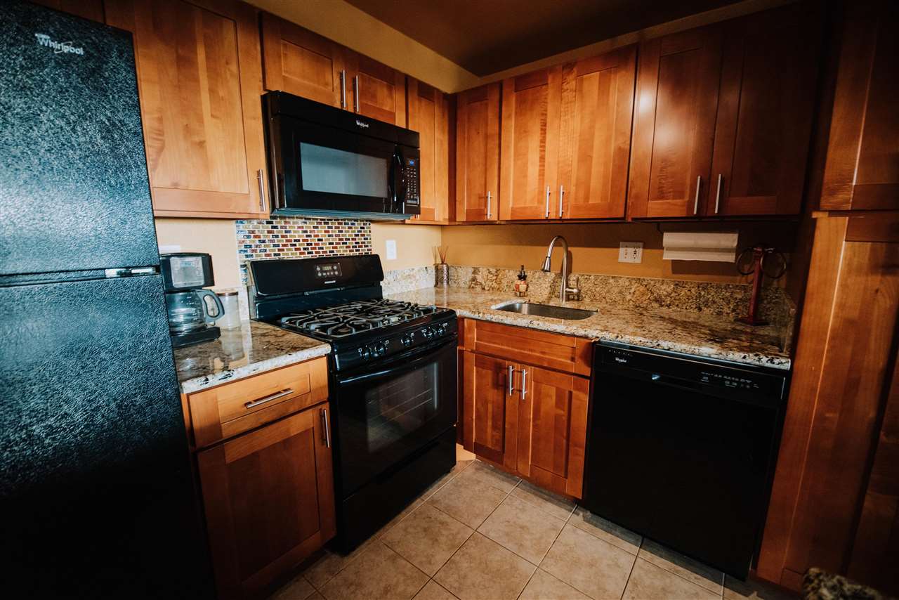 2531 South Kihei Road, Unit D210 Kihei, HI 96753 - Photo 2 of 23 a kitchen with granite countertop stainless steel appliances a stove sink and microwave