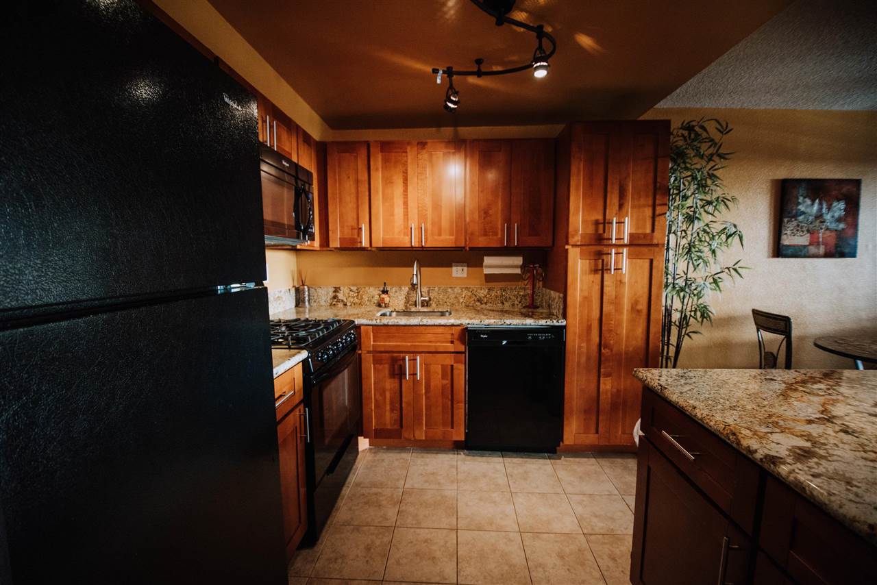 2531 South Kihei Road, Unit D210 Kihei, HI 96753 - Photo 3 of 23 a kitchen with granite countertop stainless steel appliances and wooden cabinets