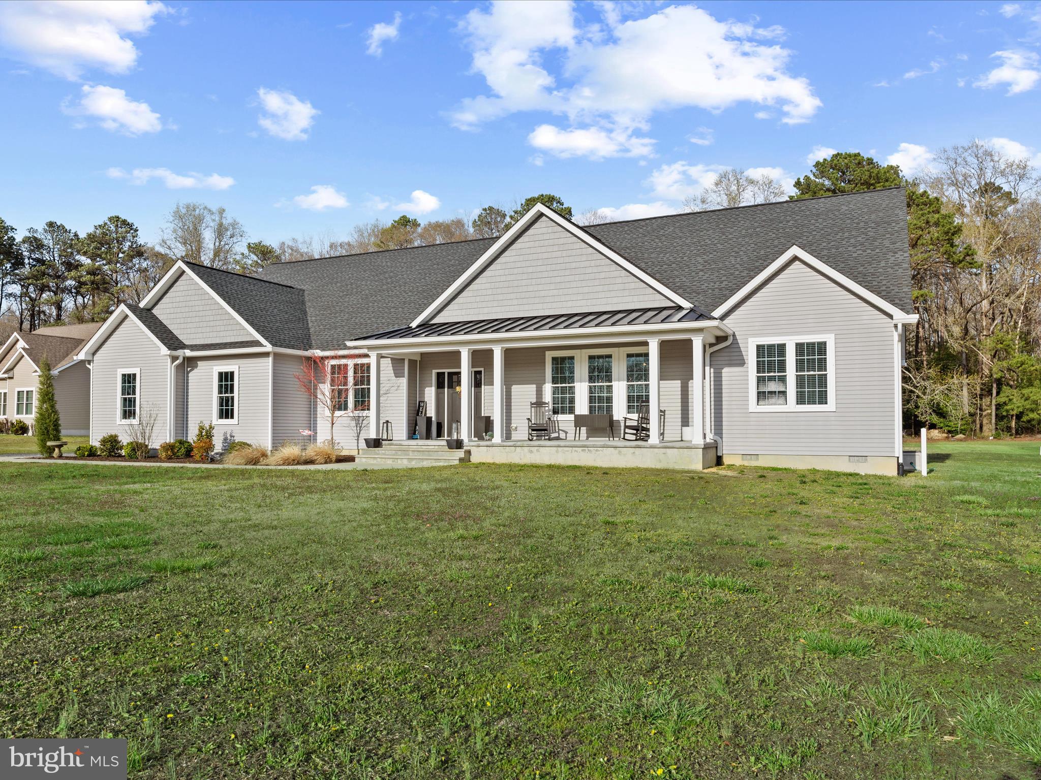a view of a house with a big yard and large trees