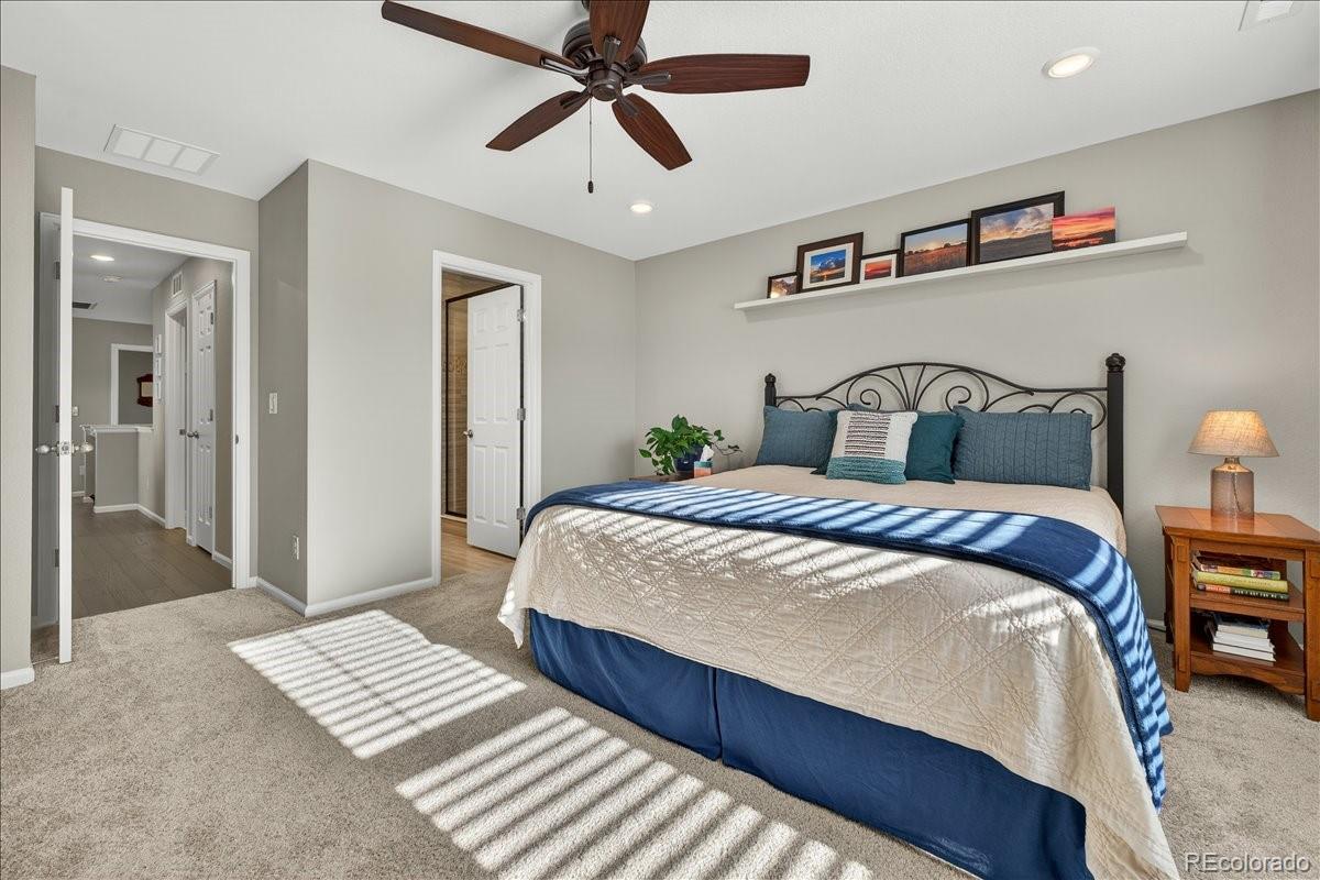 9793 Banner Peak Loop Littleton, CO 80125 - Photo 20 of 42 a bedroom with beds and a chandelier