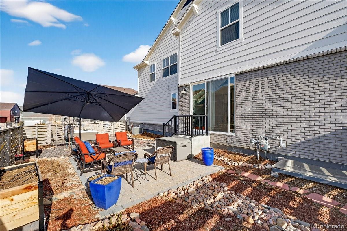 9793 Banner Peak Loop Littleton, CO 80125 - Photo 26 of 42 a view of a patio with table and chairs under an umbrella